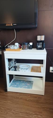 a white cabinet with a tv on top of it at Suíte Alto Afonso Pena in Belo Horizonte