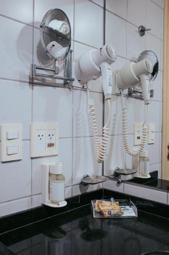 a group of white robots hanging on a wall at Batel Luxury - Próx Pátio Batel in Curitiba