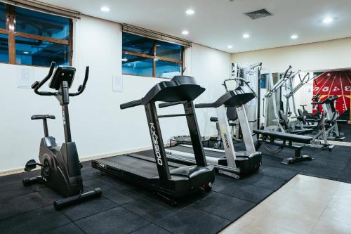a gym with several tread machines in a room at Batel Luxury - Próx Pátio Batel in Curitiba