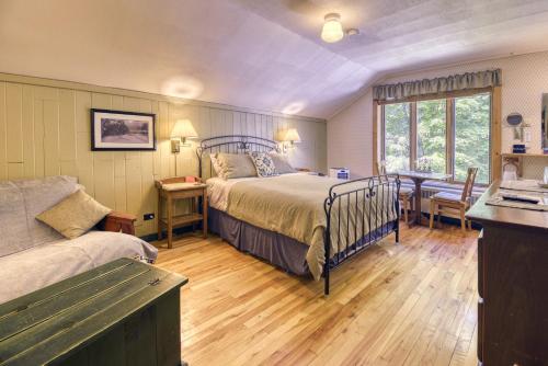 a bedroom with a bed and a table and a couch at Auberge Le Lupin-Self Check-in in Mont-Tremblant