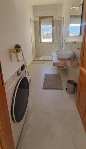 a bathroom with a sink and a toilet and a tub at Mare & Monti Casa Vacanze in Teulada