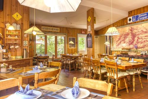 un restaurant avec des murs en bois, des tables et des chaises dans l'établissement Auberge Le Lupin-Self Check-in, à Mont-Tremblant