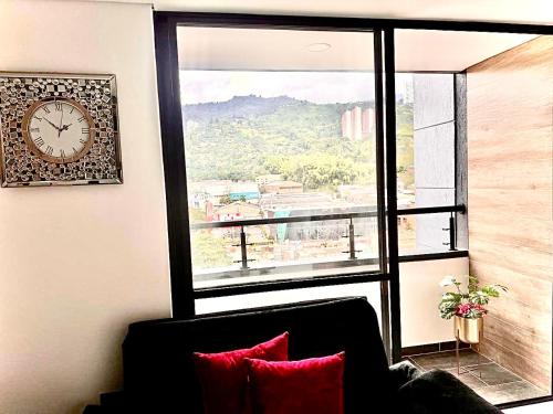 a room with a large window with a clock on the wall at Apartamento Premium Sabaneta in Sabaneta