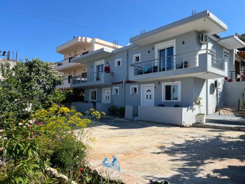 萨兰达Eri Rooms的一座白色的大房子,前面有一座院子