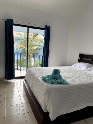 a bed with a towel on it in a bedroom at Charming Condo Orchidea in Coco