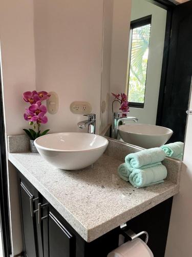 a bathroom with two sinks and a large mirror at Charming Condo Orchidea in Coco