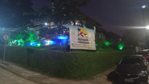 a sign in front of a building at night at Blu Hostel in Blumenau