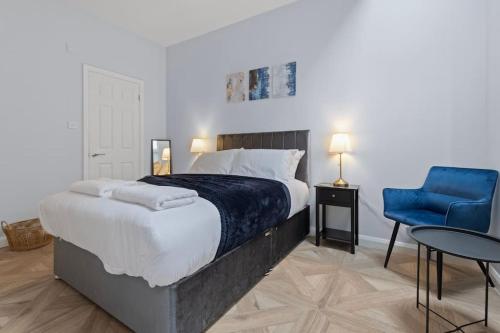 a bedroom with a large bed and a blue chair at Modern Apartment Off-Road Parking-Twin Room Suite 4 in Nottingham