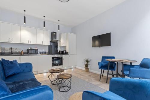 a living room with blue furniture and a kitchen at Modern Apartment Off-Road Parking-Twin Room Suite 4 in Nottingham