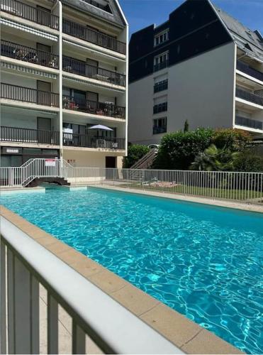 une grande piscine devant un immeuble dans l'établissement Appartement Trouville Duplex piscine chauffée, à Trouville-sur-Mer