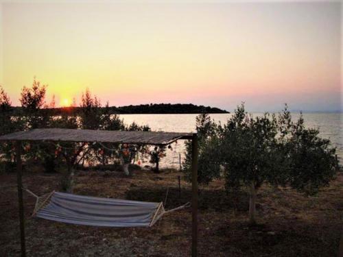 a tent on the beach with a sunset in the background at ARTE MARE d'Irene in Spárton