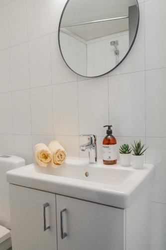 a white bathroom with a sink and a mirror at Maristova apartment 110 in Filefjell