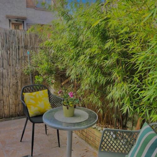 une terrasse avec une table, des chaises et une plante dans l'établissement T2 jardin privatif 20mn de Paris centre -Disneyland, à Villiers-sur-Marne