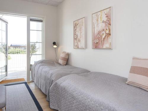 a bedroom with two beds and a large window at 4 person holiday home in Ringkøbing-By Traum in Ringkøbing