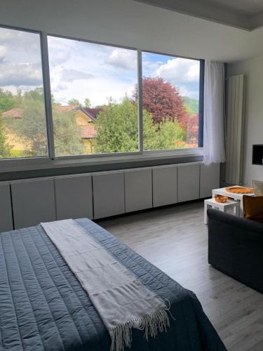 a bedroom with a bed and a large window at Son Sogni Holiday House in Leggiuno