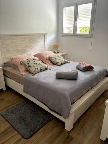Una cama con almohadas en un dormitorio. en Au domaine du commandant, en Bouillante