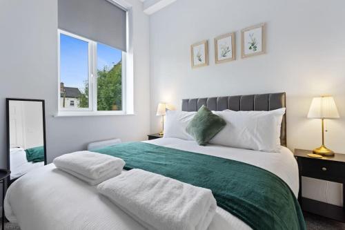a bedroom with a large bed with two towels on it at Modern Apartment Free Parking Double Bed Suite 5 in Nottingham