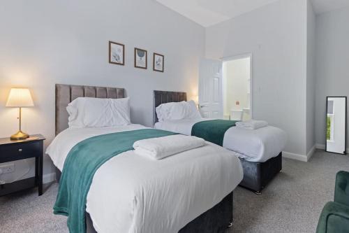 a bedroom with two beds with white sheets at Modern Apartment King with Free Parking Suite 6 in Nottingham