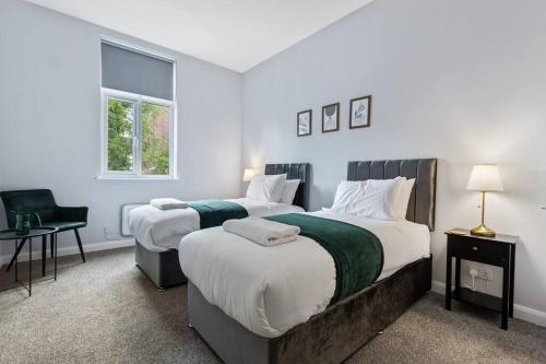 a bedroom with two beds and a chair at Modern Apartment King with Free Parking Suite 6 in Nottingham