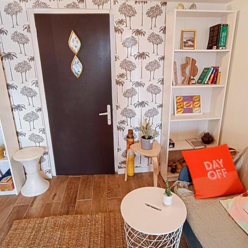 - un salon avec une porte noire et une table dans l'établissement T2 jardin privatif 20mn de Paris centre -Disneyland, à Villiers-sur-Marne