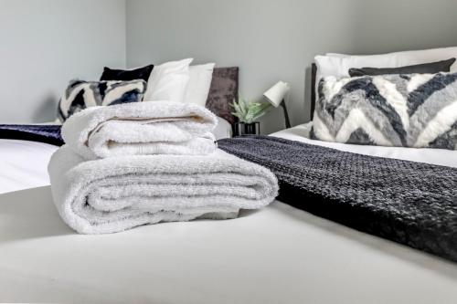 a pile of towels sitting on top of a bed at Modern, spacious house near town in Peterborough