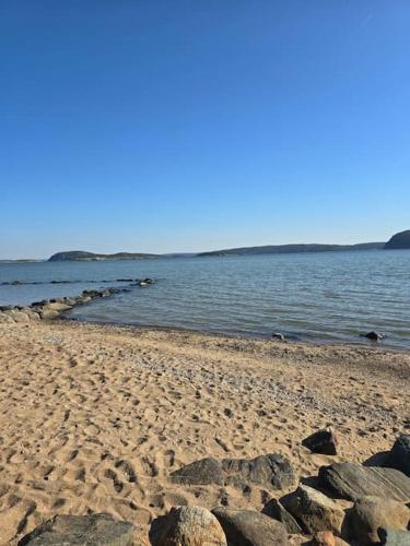 a beach with rocks and water on a sunny day at Little Red House in the Prairie in Uddevalla