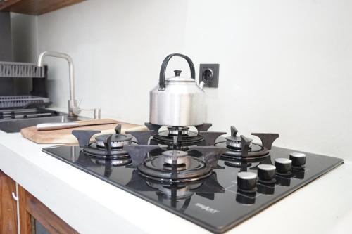 a tea kettle on top of a stove in a kitchen at CosyBe Villas in Praia do Tofo