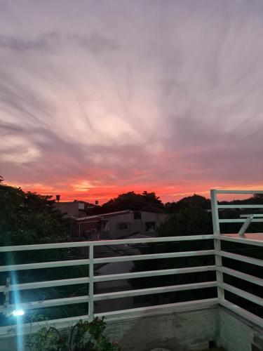 a sunset over a white fence with the sky at HOTEL AVENIDA 22 Sector de escenarios deportivos y clinicas in Santa Marta