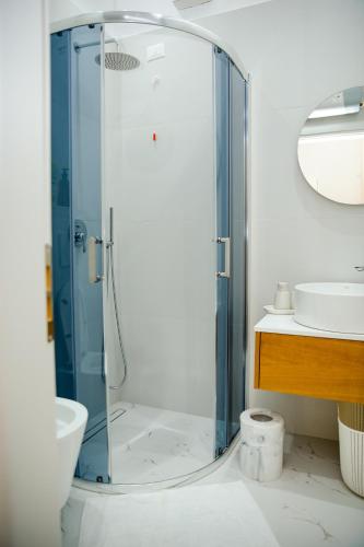 a bathroom with a glass shower with a sink at Casa di Besarb in Shkodër