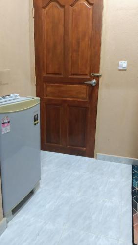a door and a refrigerator in front of a door at Teratak Cikgu Roomstay in Kampong Bukit Batu Kawi