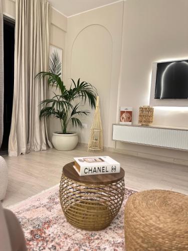 a living room with a table with a sign on it at Lungomare Luxury Sea View Apartaments in Vlorë