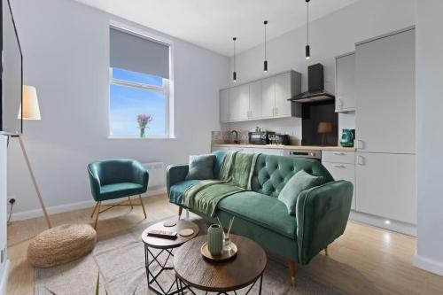 a living room with a green couch and a kitchen at Modern Apartment Spacious Double Bed Off Road Parking Suite 8 in Nottingham
