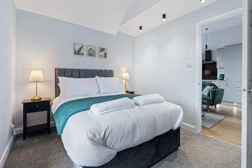 a white bedroom with a large bed with two pillows at Modern Apartment Spacious Double Bed Off Road Parking Suite 8 in Nottingham