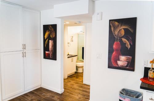 un pasillo con paredes blancas y pinturas en la pared en Cozy Modern 1-Bedroom in Koreatown, Near Hollywood Attractions, en Los Ángeles