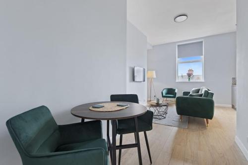 a living room with a table and green chairs at Modern Apartment Spacious Double Bed Off Road Parking Suite 8 in Nottingham