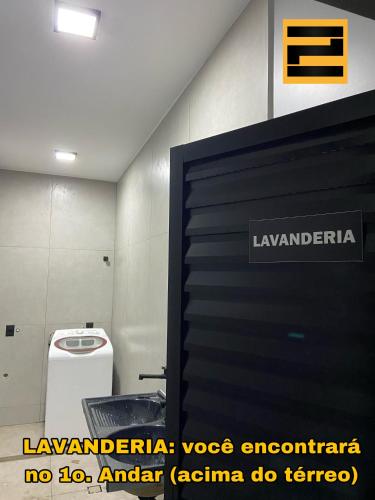 a bathroom with a toilet and a sign on the wall at Ubatuba Loft Moderno Próximo Praia e Centro Turístico in Ubatuba