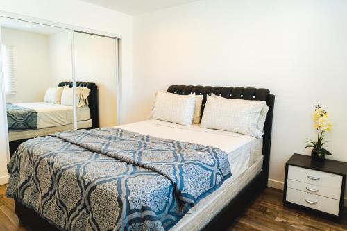 Un dormitorio con una cama grande y un espejo. en Cozy Modern 1-Bedroom in Koreatown, Near Hollywood Attractions, en Los Ángeles