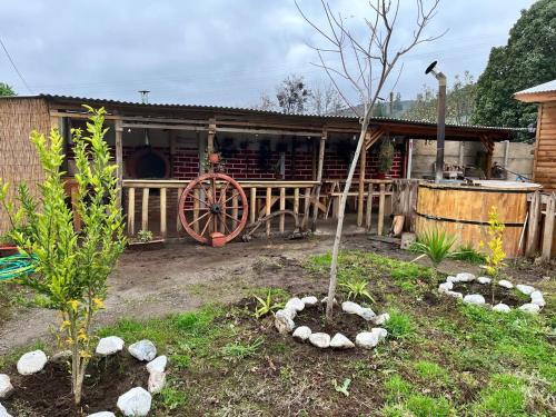 a garden with a house with a tree in the yard at Cabaña La campana in Hijuelas