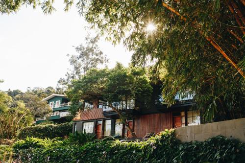 a house on a hill with trees in front of it at Vila Bambu Ilhabela, Santa Tereza in Ilhabela