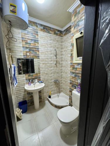 a bathroom with a toilet and a sink at Lasirena north coast Chalet With Roof , 3 rooms in Zāwiyat ‘Abd al Mun‘im