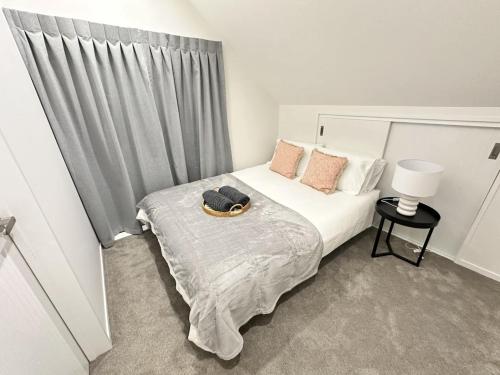 a bedroom with a bed with a hat on it at Cozy Top-Floor Stay with Private Bathrooms and Free Parking in Auckland