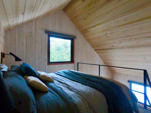 a bedroom with a bed in a wooden room at Casa Hagall Refugio de Montaña in Malalcahuello