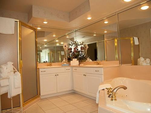 a bathroom with a tub and a large mirror at French Quarter Resort in Branson