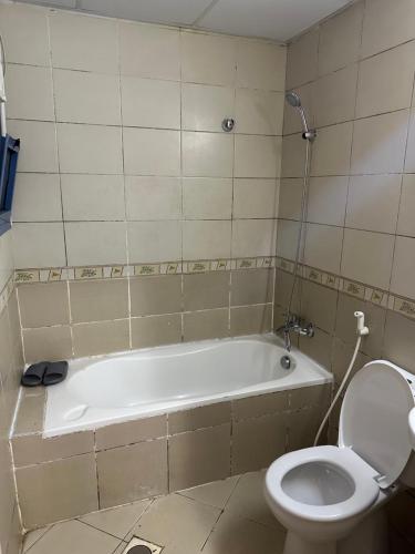a bathroom with a bath tub and a toilet at Elite Class Furnished Room in Ajman 