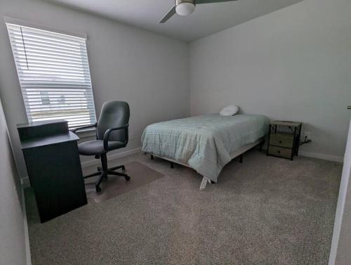 a bedroom with a bed and a desk and a chair at Vivanta Retreat in College Station