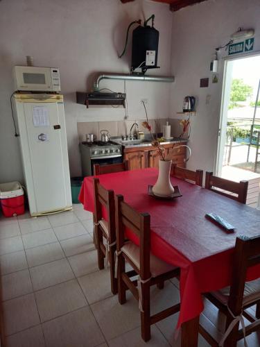 圣何塞Bungalow "El Poli 01"的厨房配有红色的桌椅和冰箱。