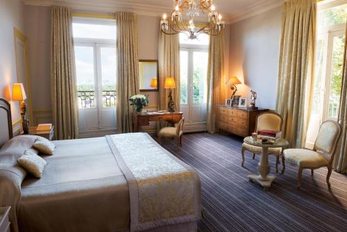 1 dormitorio con 1 cama, mesa y sillas en Pavillon Henri IV - Hotel Restaurant Terrasse, en Saint-Germain-en-Laye