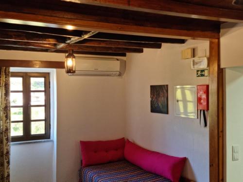 a room with a red couch and a window at Casarão do Alva in Penalva de Alva