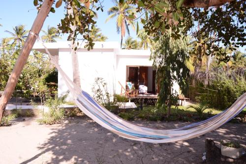 a hammock in front of a house at CosyBe Villas in Praia do Tofo