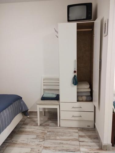 1 dormitorio con escritorio y TV en la pared en Casa cronopio en Ushuaia